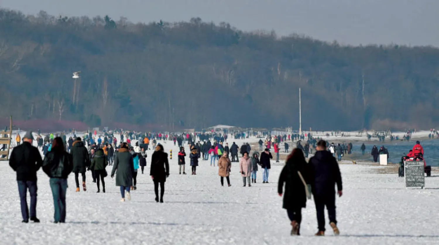 ازدحام على شاطئ يغطيه الثلج عند بحر البلطيق في شمال بولندا أمس رغم التحذيرات من الوباء (إ.ب.أ)