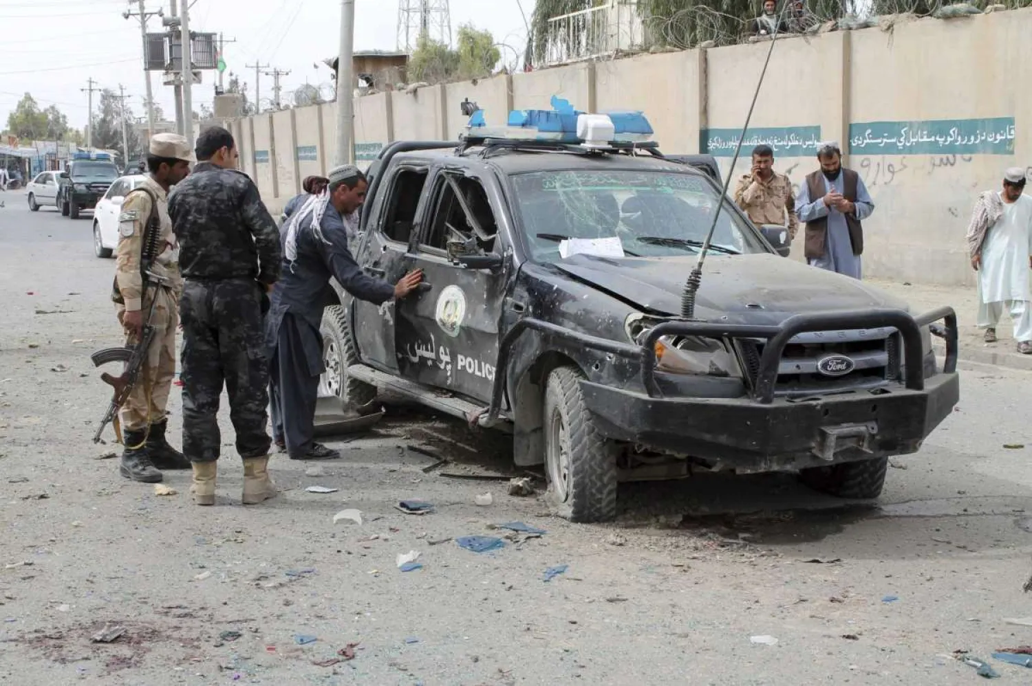 Security personnel inspect the site of a deadly roadside bomb in Helmand province, southern Afghanistan, Sunday, Feb. 21, 2021. AP