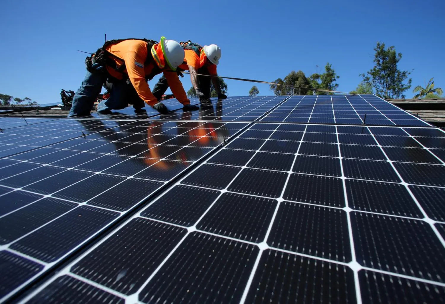 Solar installers from Baker Electric place solar panels on the roof of a residential home in Scripps Ranch, San Diego, California, US October 14, 2016. REUTERS/Mike Blake/File Photo