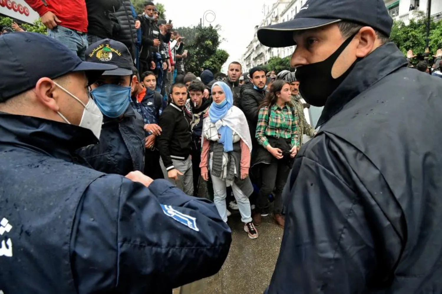 جزائريون يتجمعون أمام أفراد من الشرطة خلال احتجاجات في الذكرى الثانية للحراك (أ.ف.ب)