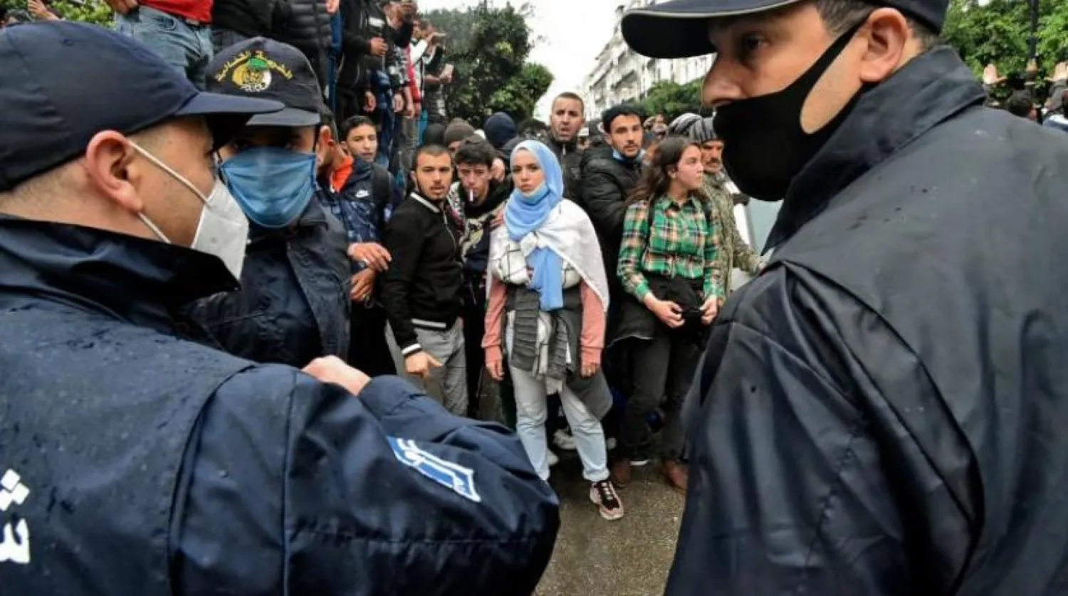 Protestoların ikinci yıldönümünde polis memurları karşısında toplanan Cezayirliler (AFP)