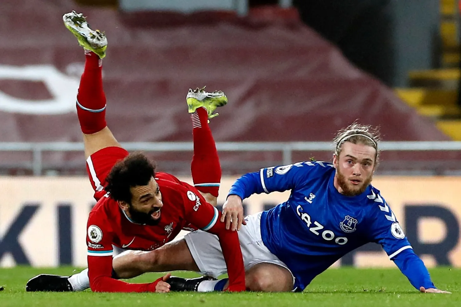 Mohamed Salah (L) of Liverpool and Tom Davies of Everton fall at Anfield during the Merseyside derby. (AFP)