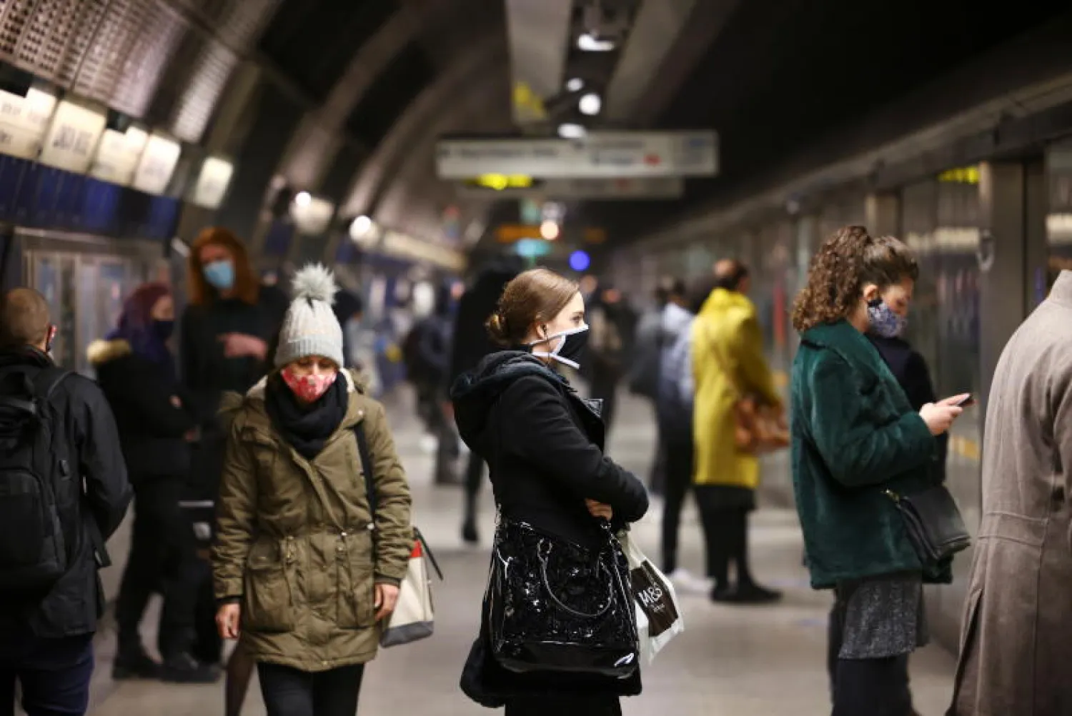أشخاص يضعون الكمامات في محطة مترو أنفاق بلندن (رويترز)
