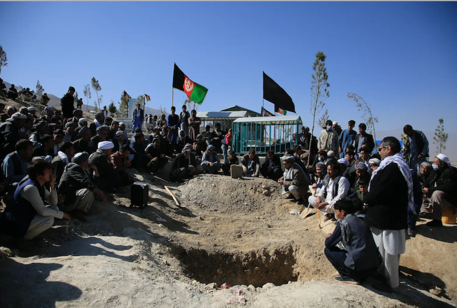  in this Oct. 25, 2020 file photo, Afghan men bury a victim of a suicide attack that targeted an education center, in Kabul Afghanistan. (AP Photo/Mariam Zuhaib, File)