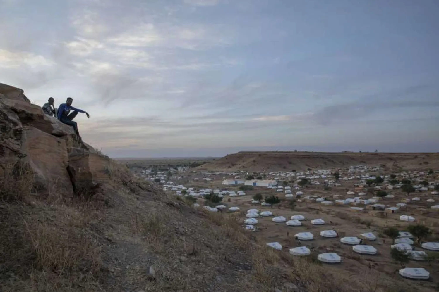 In this Dec. 14, 2020 file photo, Tigray men sit atop a hill overlooking part of the Umm Rakouba refugee camp, hosting people who fled the conflict in the Tigray region of Ethiopia, in Qadarif, eastern Sudan. | AP