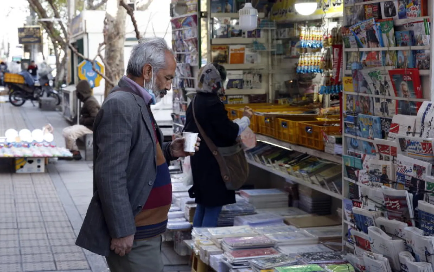 مواطن إيراني يقرأ عناوين الصحف في طهران (إ.ب.أ)