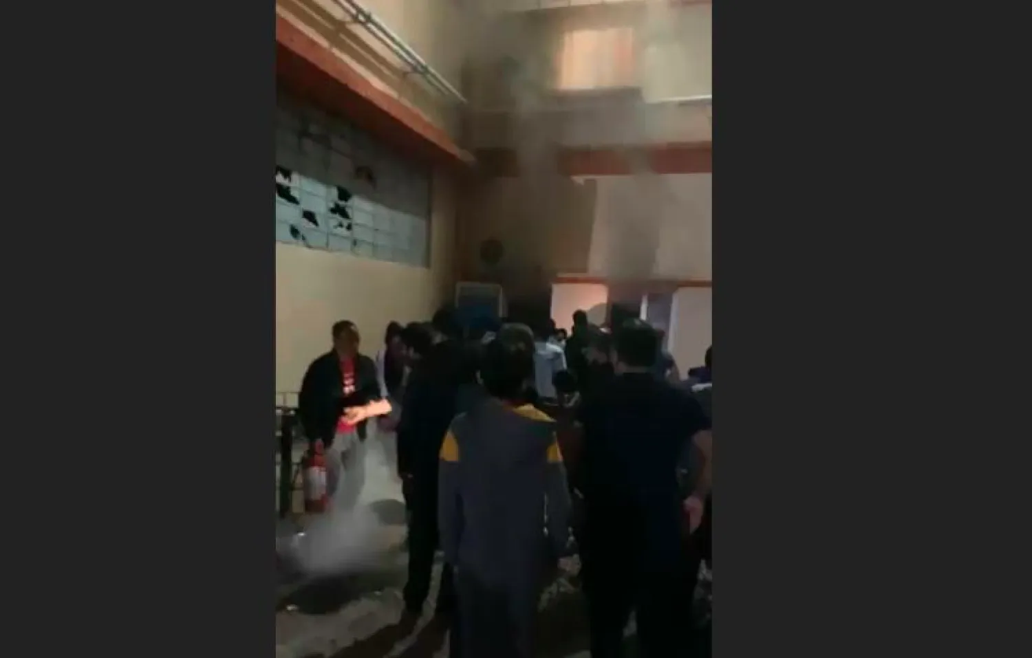 Migrants in the Thiva asylum seeker accommodation facility north of Athens gathered as a fire burns in a container building February 2021 | Photo: Screenshot