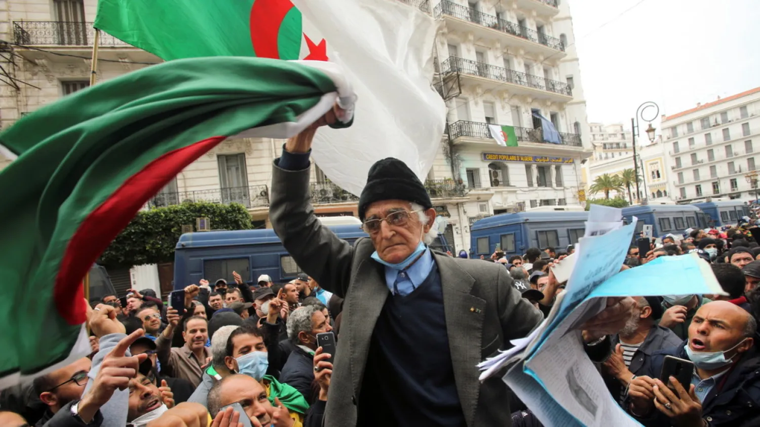 A demonstrator carries a national flag during a protest to mark the second anniversary of a mass protest movement demanding political change, in Algiers, Algeria February 22, 2021. REUTERS/Ramzi Boudina