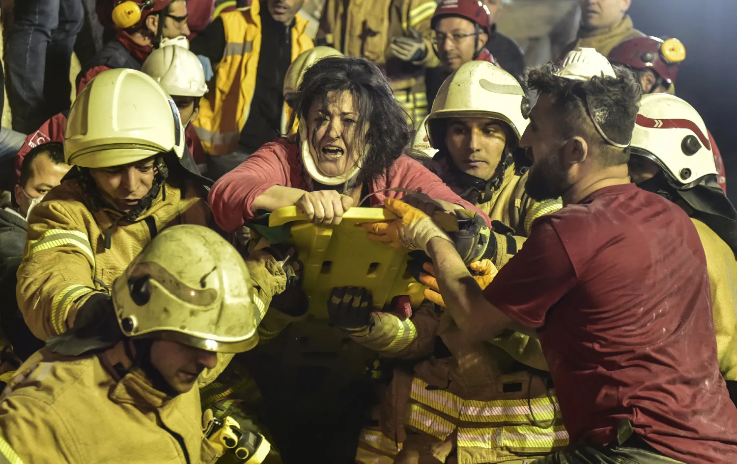 A woman reacts after rescue workers had pulled her out the rubble of an eight-story building which collapsed in Istanbul, Wednesday, Feb. 6, 2019. (DHA via AP)