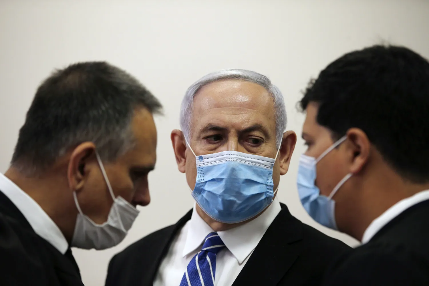 Israeli Prime Minister Benjamin Netanyahu, wearing a face mask in line with public health restrictions due to the coronavirus pandemic, looks at his lawyer inside the court room as his corruption trial opens at the Jerusalem District Court, Sunday, May 24, 2020. (Ronen Zvulun/ Pool Photo via AP)