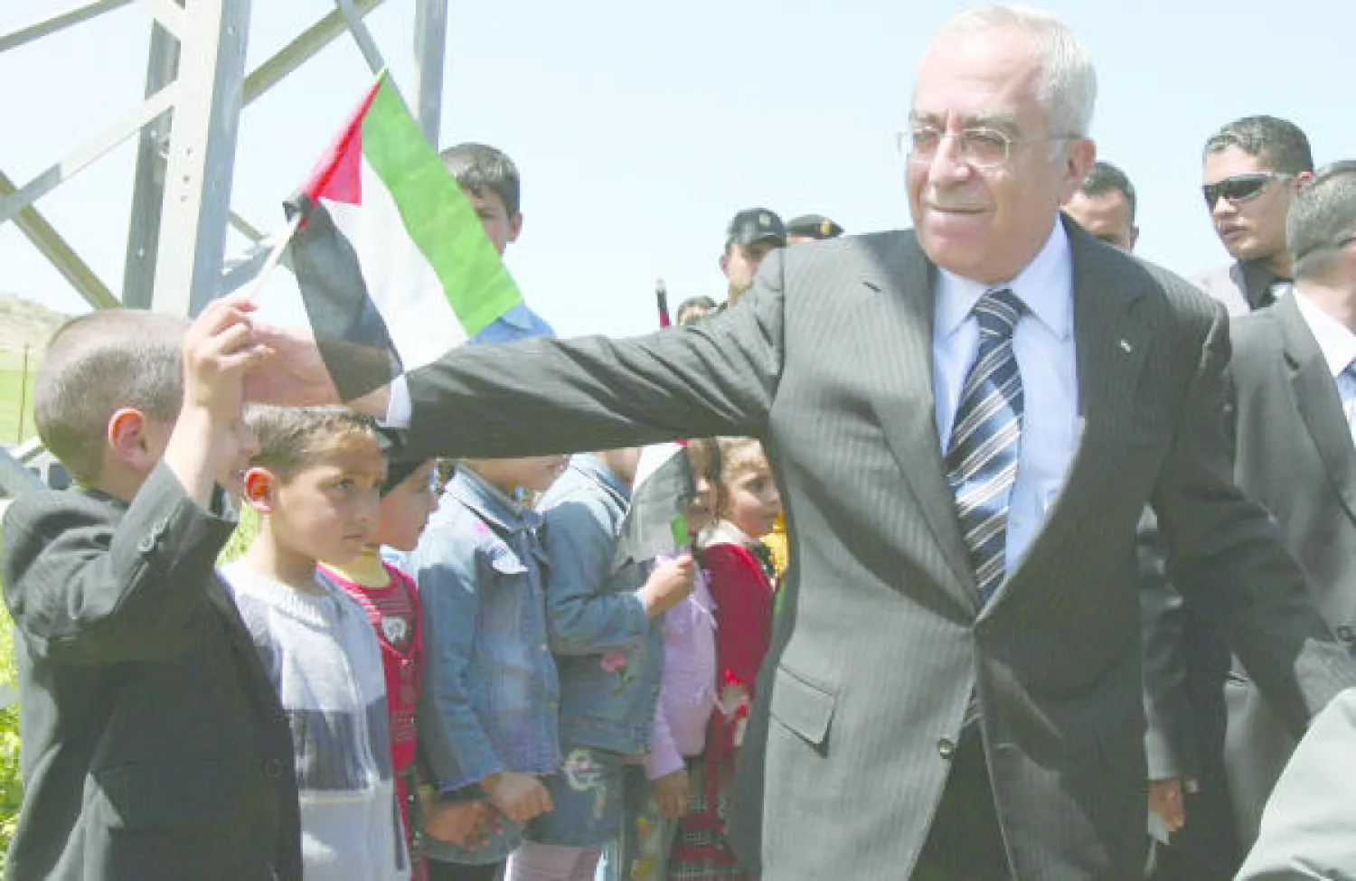 رئيس الوزراء الفلسطيني الأسبق سلام فياض يحيي اطفال قرة طوباس في الضفة الغربية في زيارة تمت 2009  (غيتي
