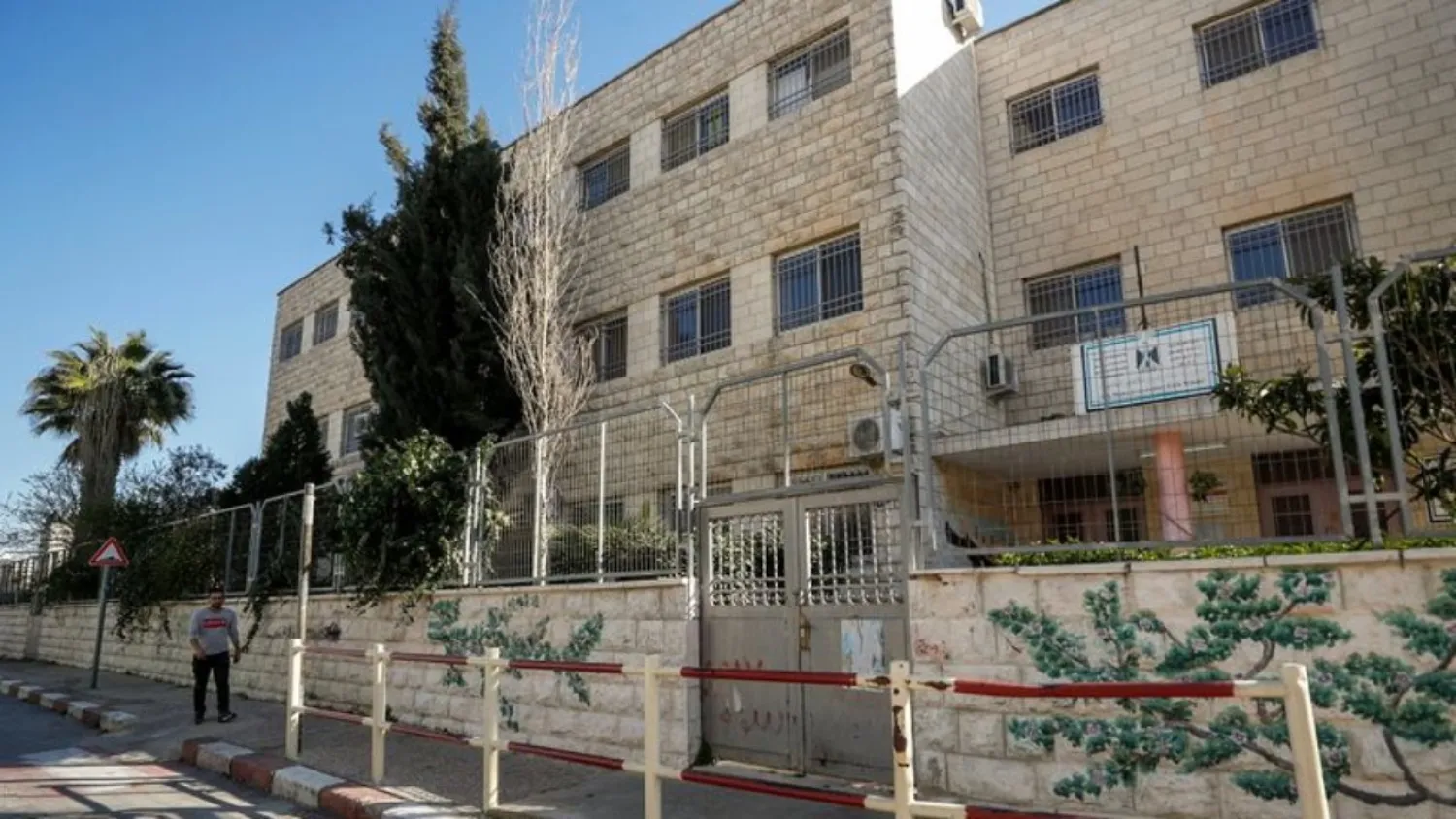 A Palestinian man walks past a closed school, amid the coronavirus disease (COVID-19) outbreak, in Ramallah in the Israeli-occupied West Bank February 27, 2021. (Reuters)