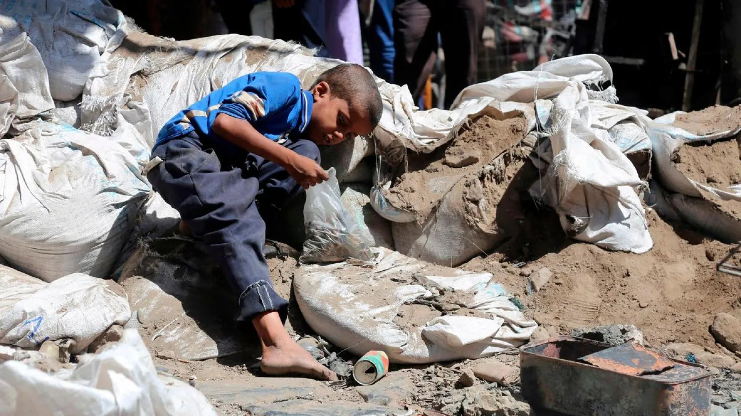 A Yemeni boy searches a street in Taez city for bullet casings to sell as scrap metal, on April 27, 2019. AFP