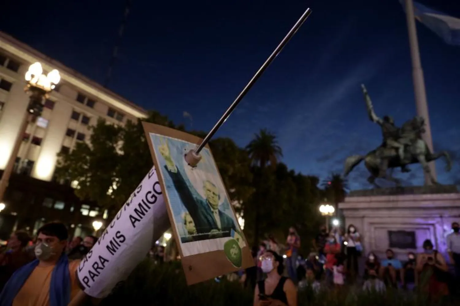 متظاهرون يحملون مجسماً لحقنة تطعيم ضد فيروس كورونا أمام قصر كاسا روسادا الرئاسي في بوينس آيرس (أ.ف.ب)