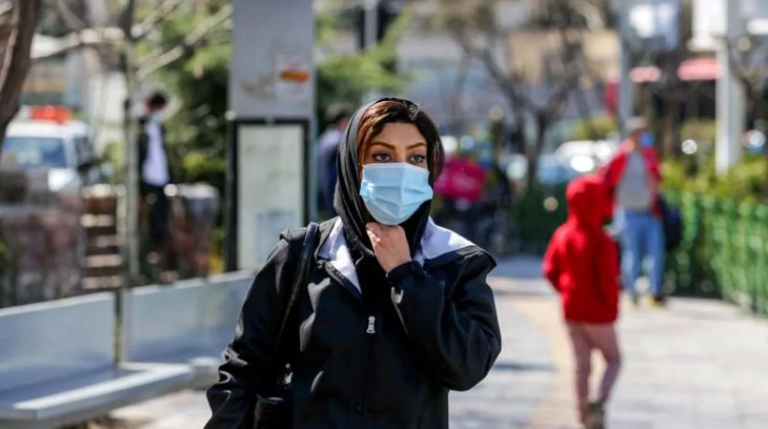 İran'ın başkenti Tahran'ın merkezindeki caddede bir kadın yürüyor. (AFP)