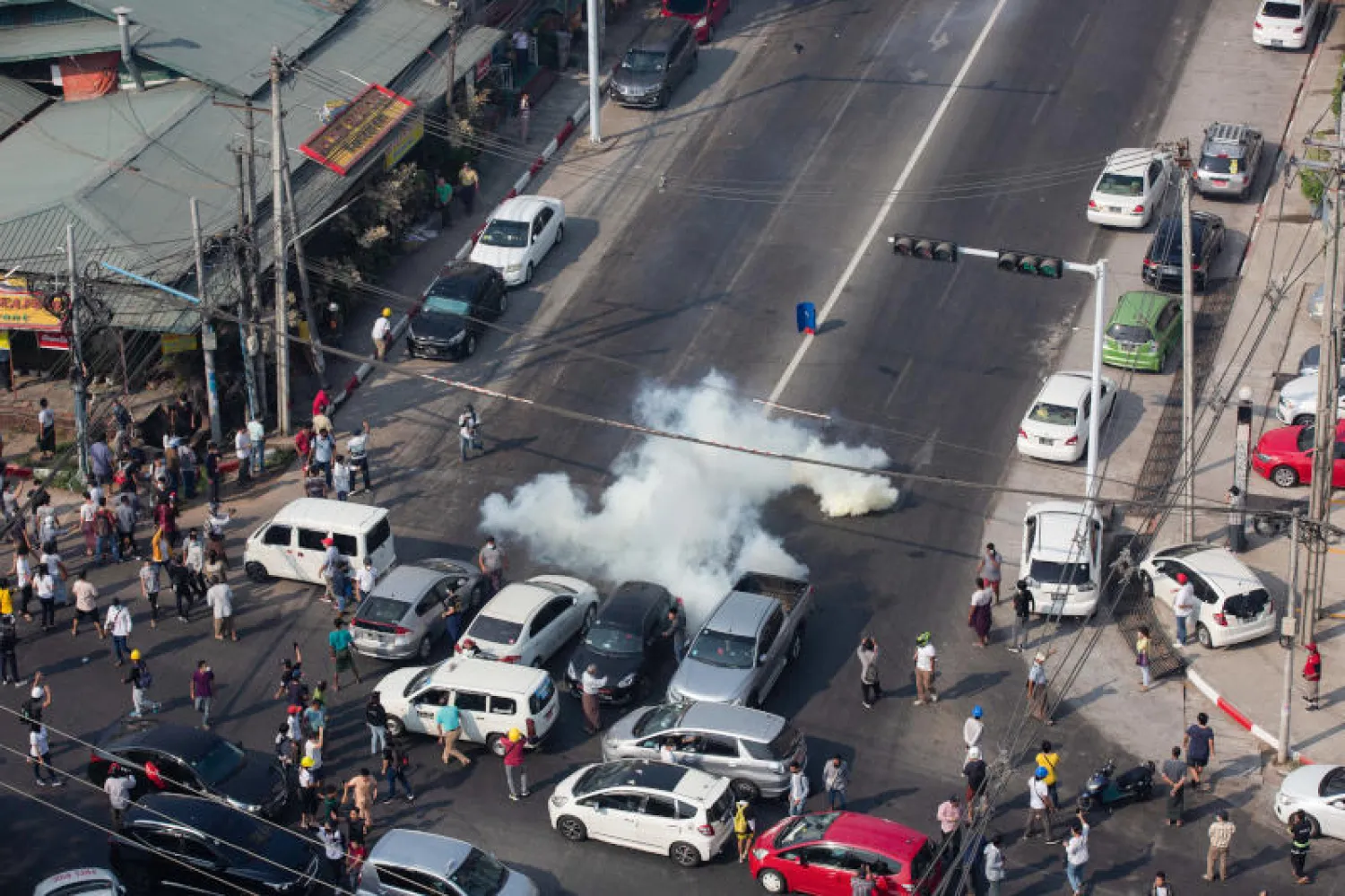 متظاهرون يفرون من الغاز المسيل للدموع خلال احتجاج على الانقلاب العسكري (د.ب.أ)
