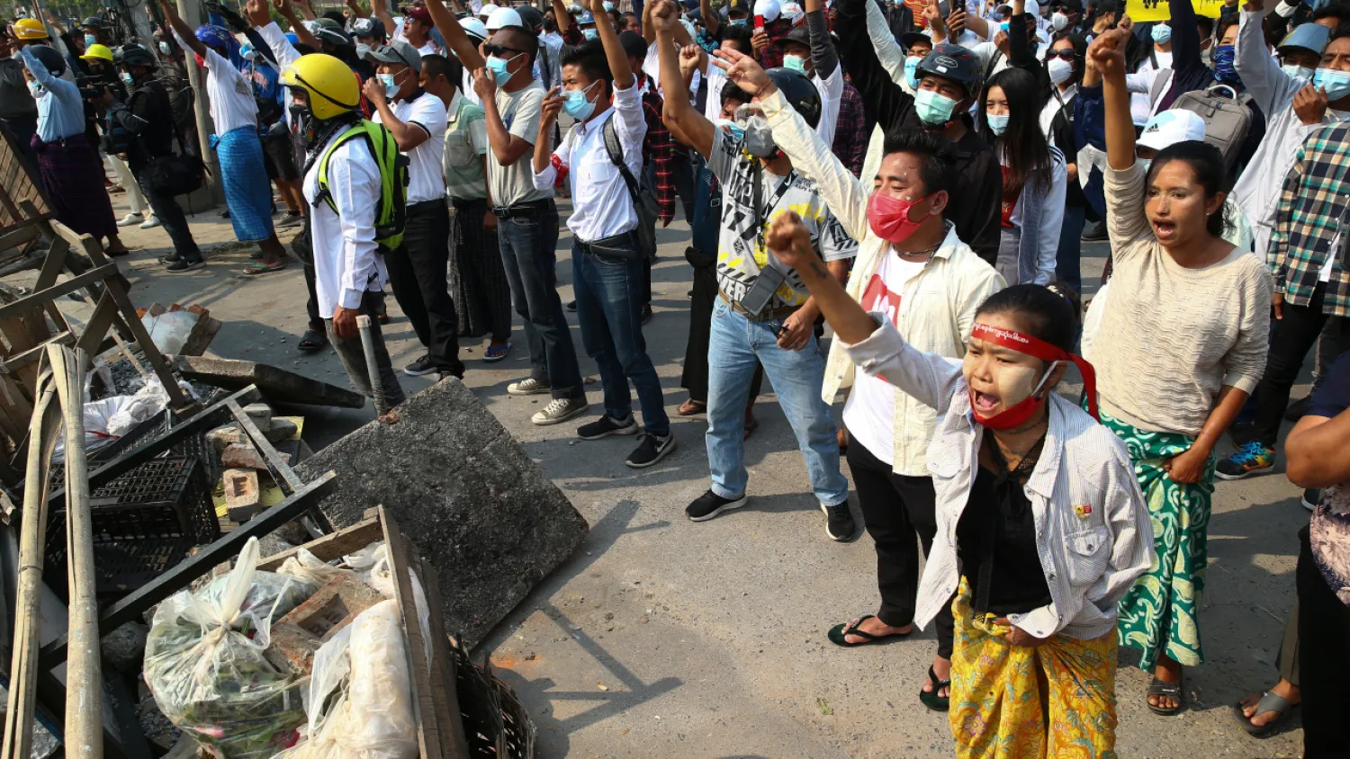 Protesters shout slogans behind the blockages they set up during a protest against the military coup in Yangon, Myanmar, Sunday, Feb. 28, 2021. AP Photo