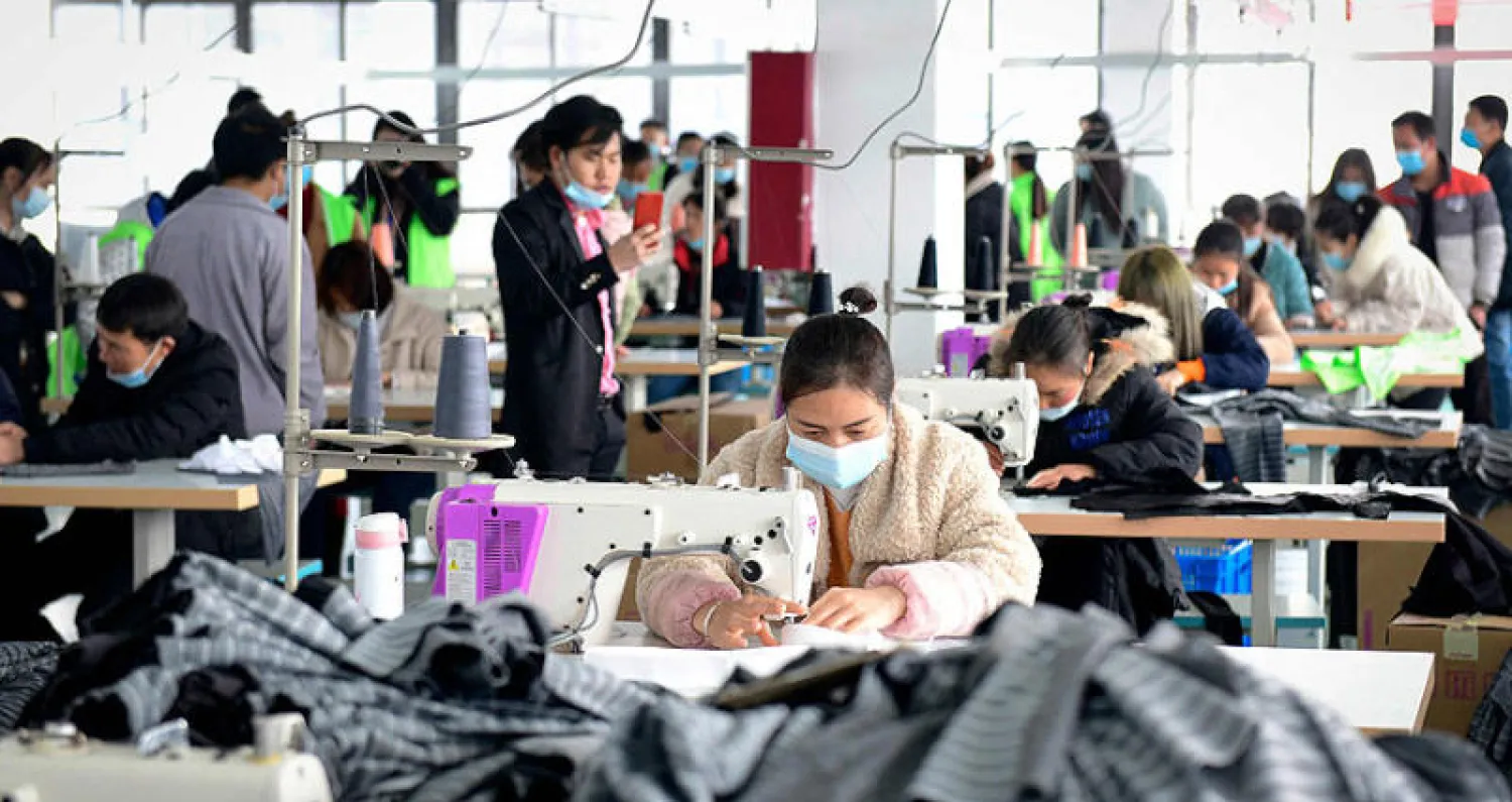 عمال داخل مصنع ملابس في الصين (أ.ف.ب)