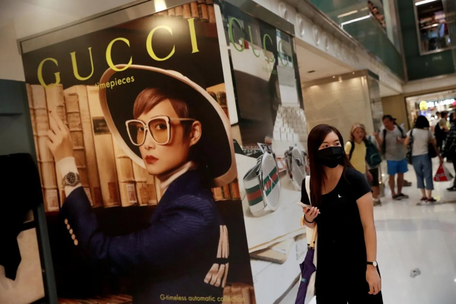 A woman walks past a Gucci advertising poster at New Town Plaza in Sha Tin, Hong Kong, China November 3, 2019. (Reuters)