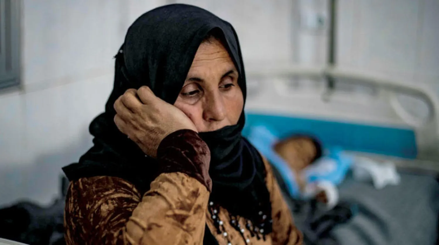 امرأة مع ابنها بمستشفى في الحسكة بعدما أُصيب بحريق في مخيم للنازحين في الهول شمال شرقي سوريا أول من أمس (أ.ف.ب)
