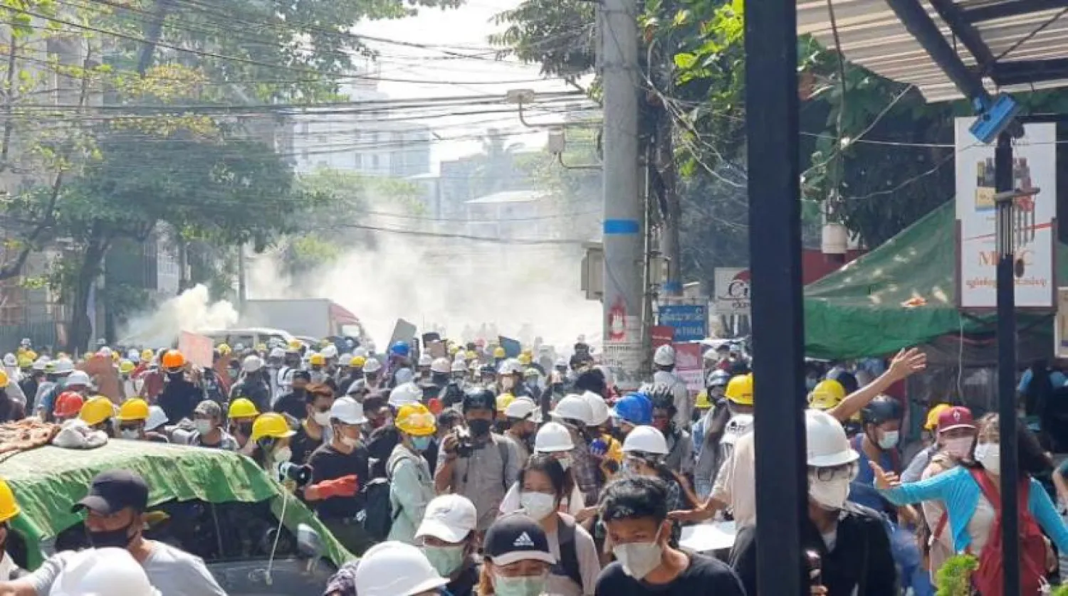 Yangon’daki göstericiler polisin sıktığı göz yaşartıcı gazdan kaçıyor (Reuters)