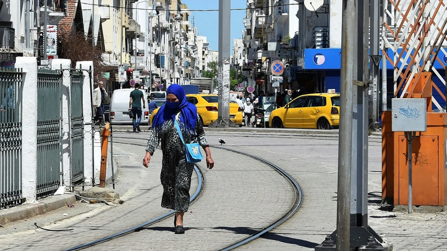 A woman wearing a face mask due to the COVID-19 coronavirus pandemic walks between the rails of the Tunis Metro in the center of the capital Tunis. (Getty Images)