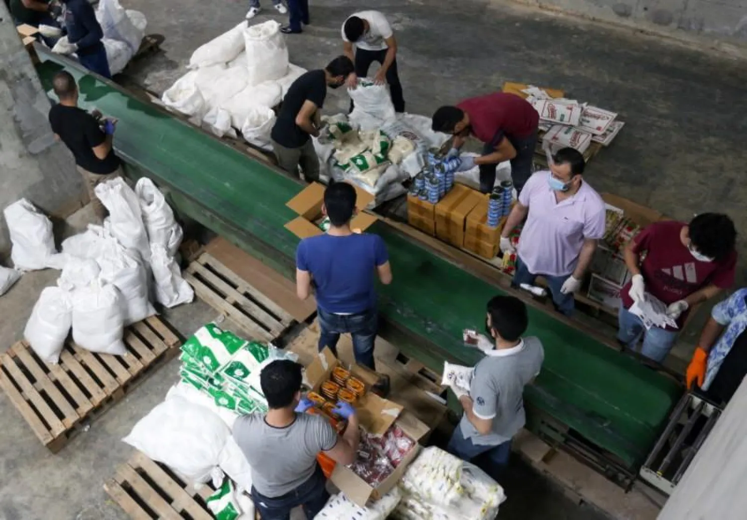 Volunteers wearing protective masks and gloves sort boxes with food for distribution to people in need, in Beirut, Lebanon May 29, 2020. REUTERS/Aziz Taher