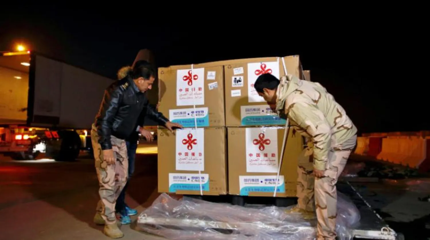 Bağdat Uluslararası Havalimanı’ndaki kargo çalışanları Sinopharm aşının ilk partisini indiriyor (AP)