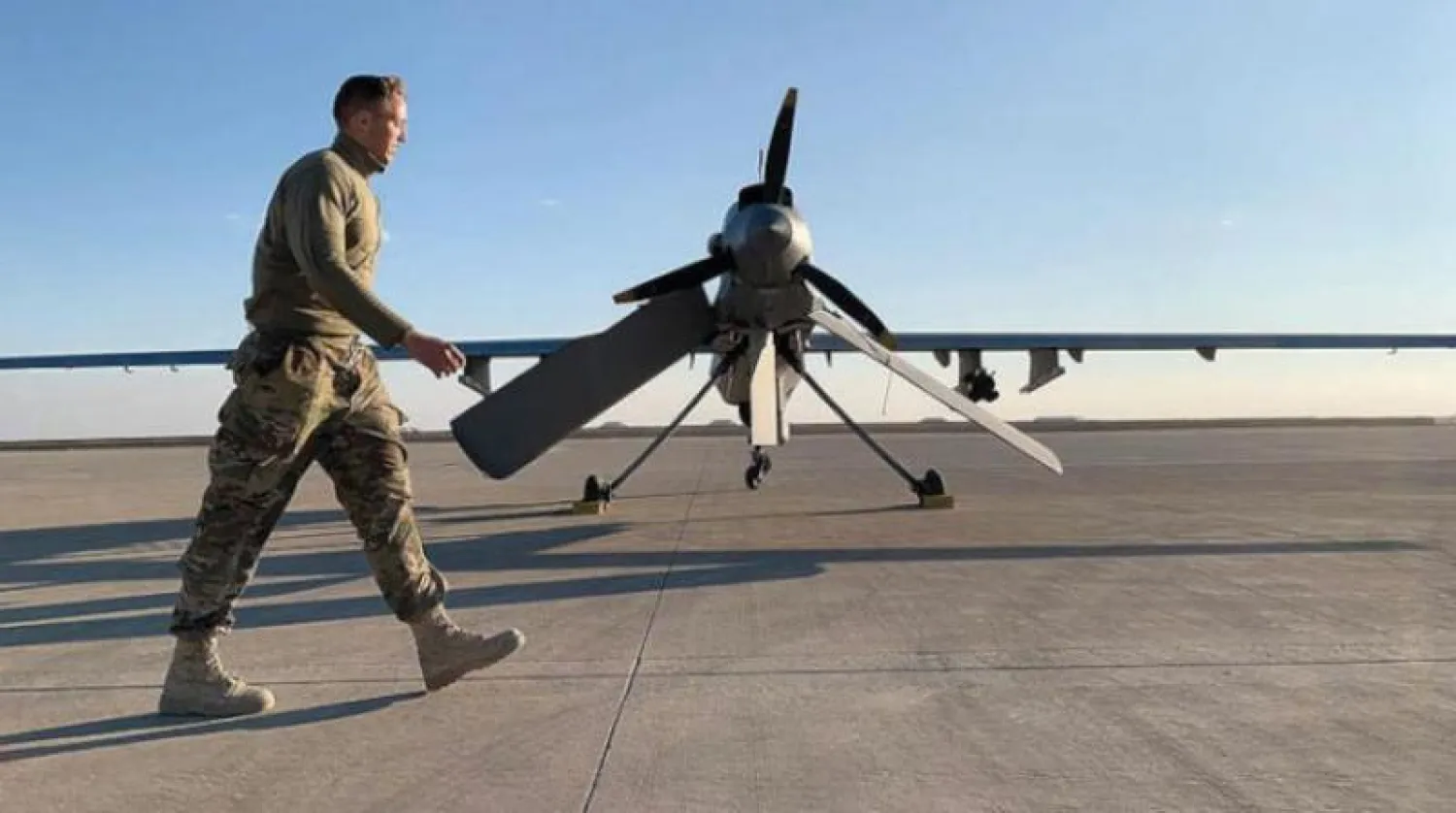 جندي أميركي يمر أمام طائرة مسيرة (درون) في قاعدة عين الأسد غرب العراق (أرشيفية - أ.ف.ب)