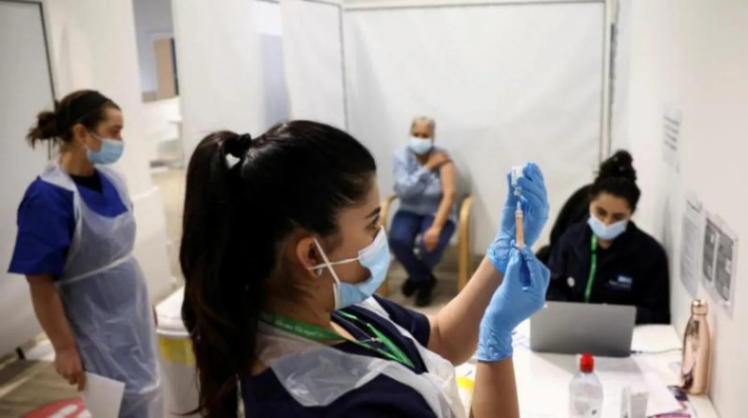 عاملة بالرعاية الصحية تحضر جرعة من اللقاح المضاد لفيروس كورونا بمركز للتطعيم في لندن (رويترز)