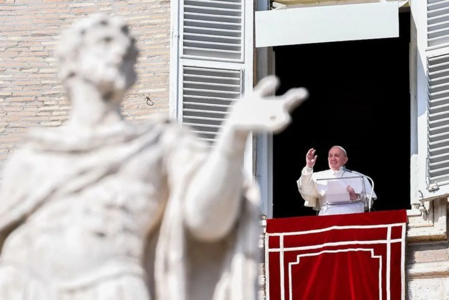Pope Francis waves from the window of the apostolic palace overlooking St. Peter's square in The Vatican on February 28, 2021 during the weekly Angelus prayer. (AFP)
