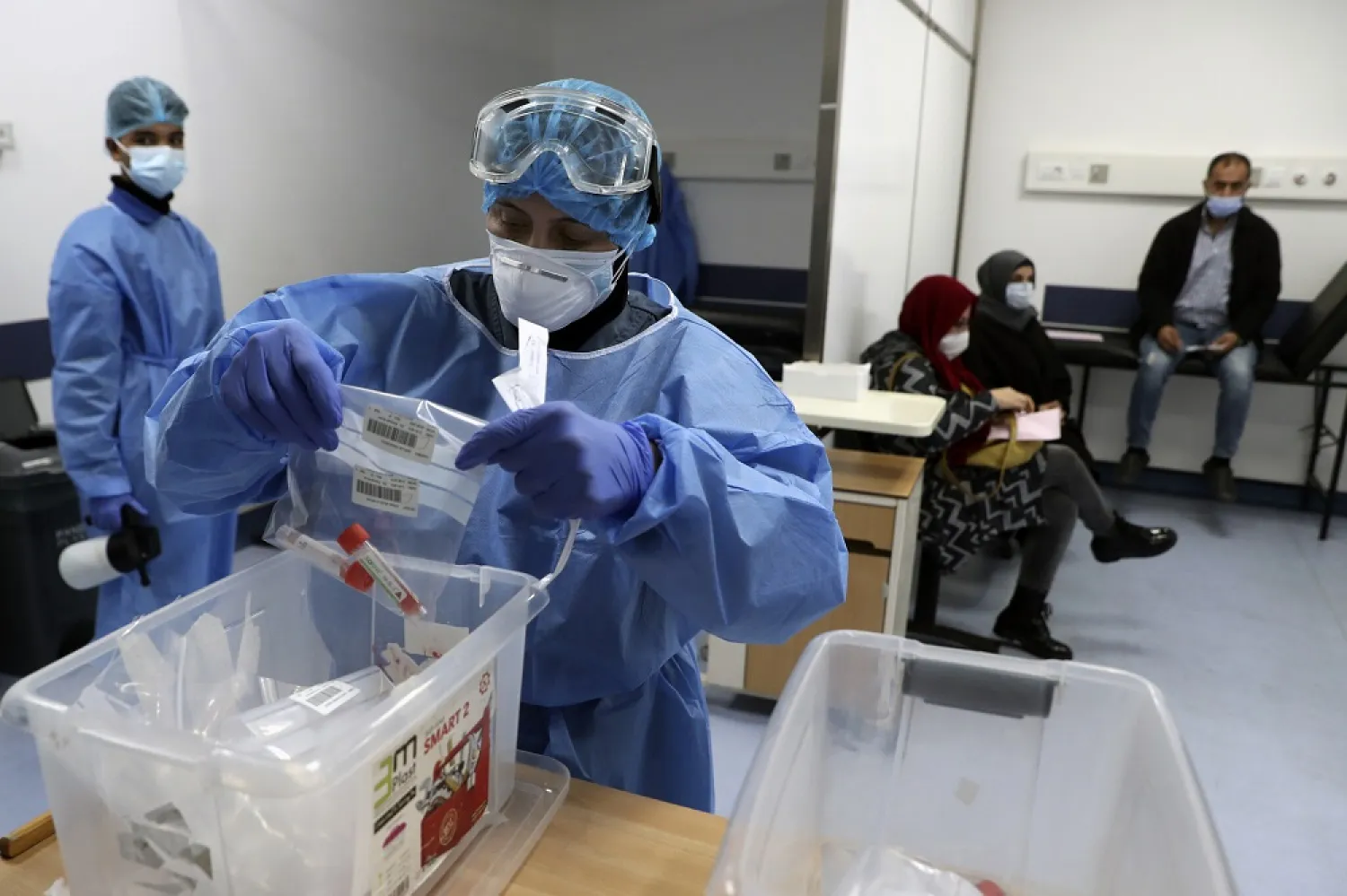A nurse in protective clothing holds coronavirus testing material, at a center in the Rafik Hariri University Hospital in Beirut, Lebanon, January 11, 2021. (AP)