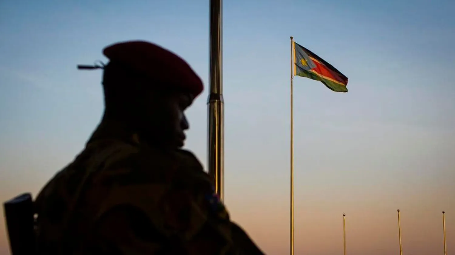 A South-Sudanese government soldier stands guard as a South Sudanese flag flies in the background. (File photo: AP)
