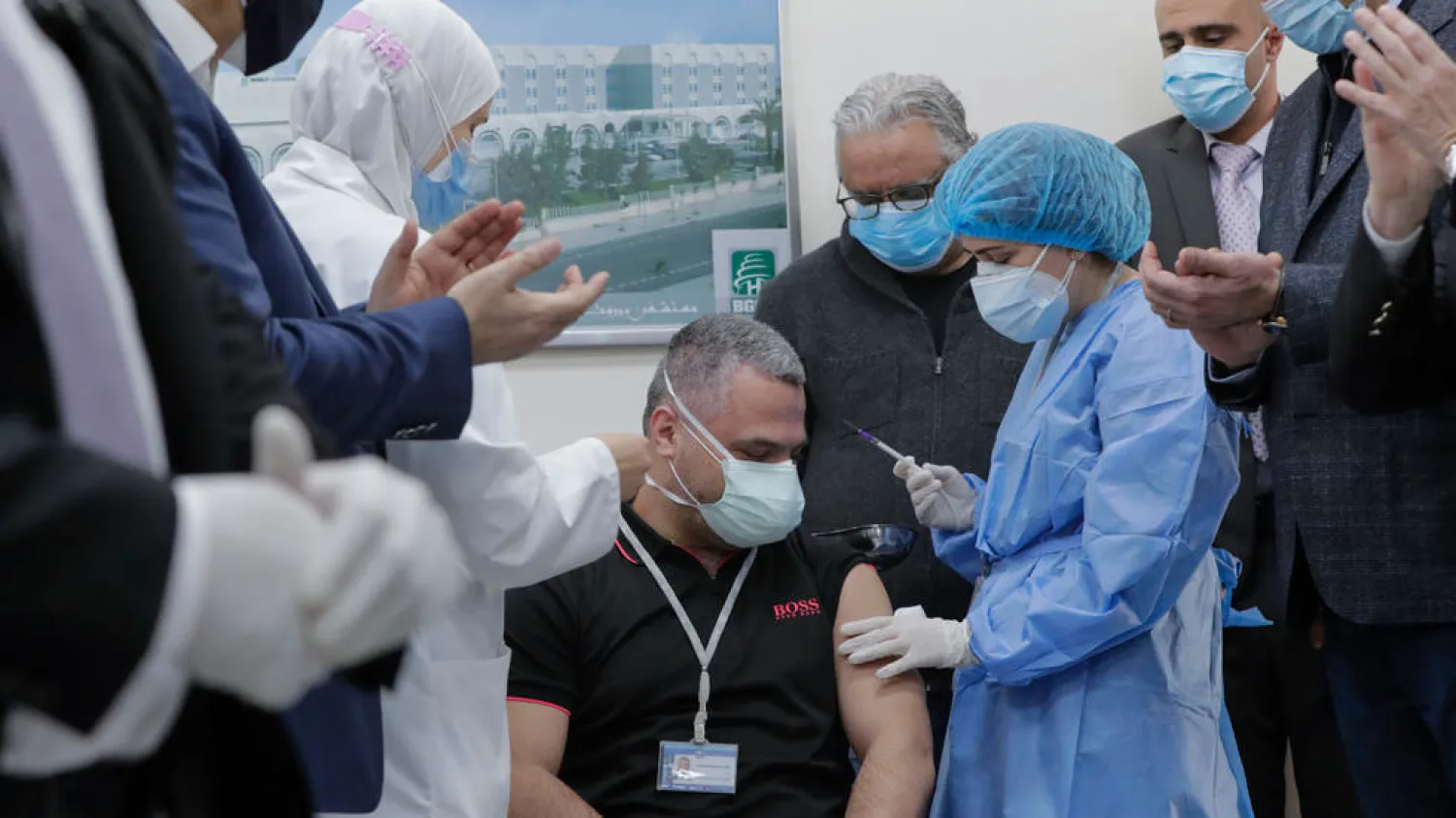 Head of the intensive care unit at Lebanon's Rafik Hariri Hospital battling the coronavirus, Mahmoud Hassoun, receives the first coronavirus jab on Valentine's Day. (AFP)
