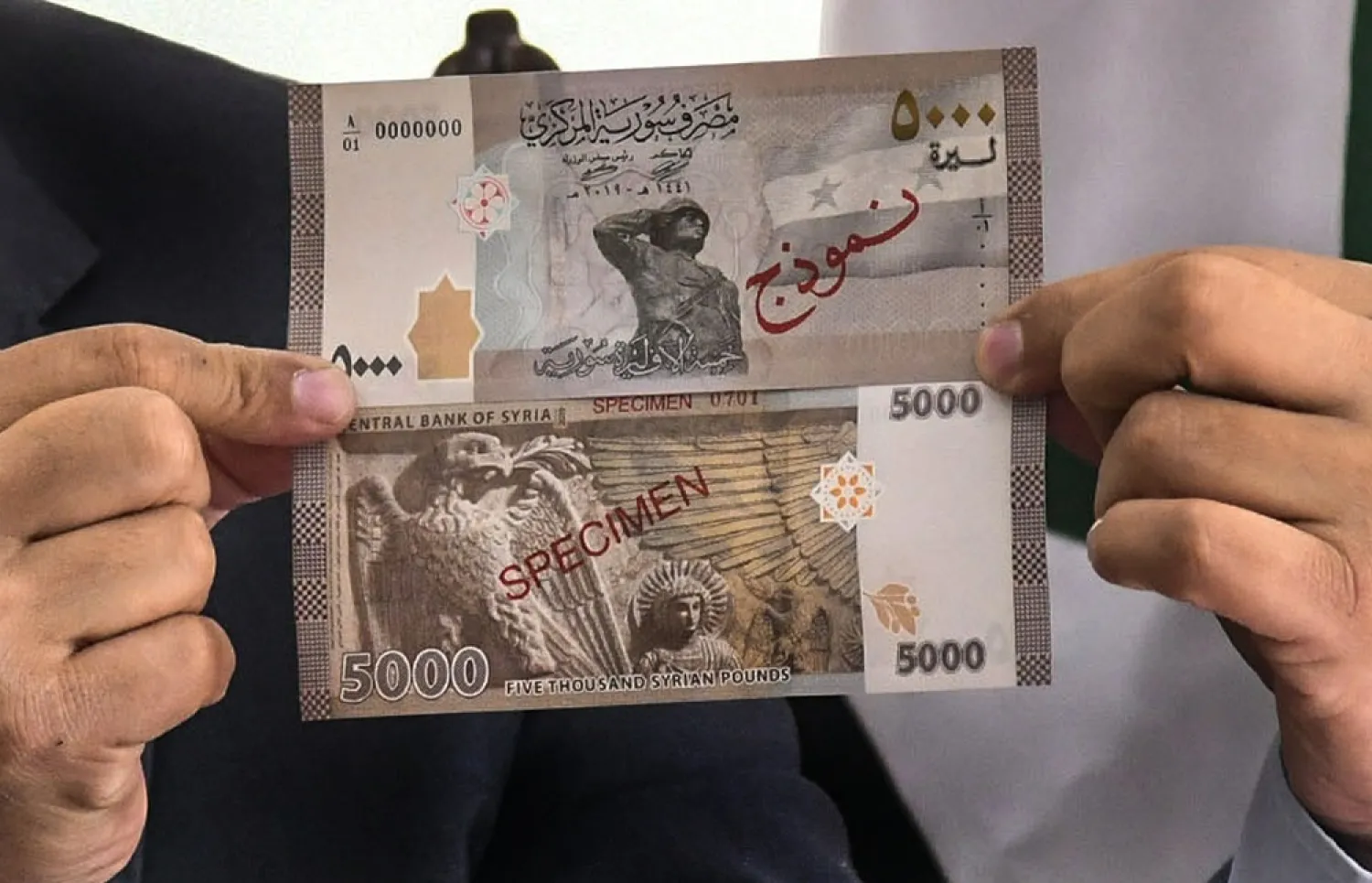 In this Jan. 24, 2021 file photo released by the Syrian official news agency, a new banknote of 5,000 Syrian pounds is revealed during a press briefing, in Damascus, Syria. (SANA via AP)