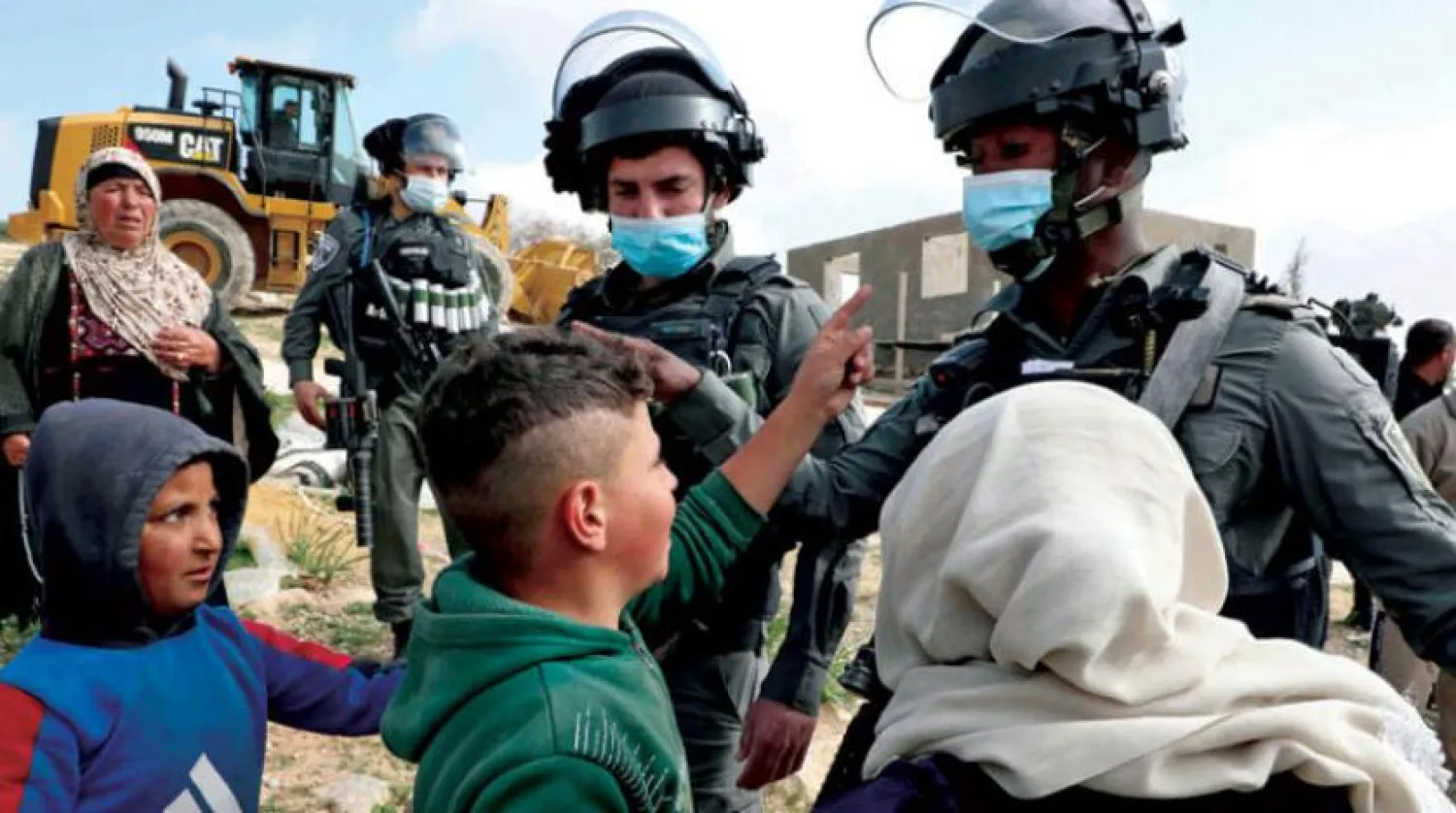 Palestinians confronting Israeli forces who were preparing to demolish their home in Yatta, south of Hebron, on Tuesday, March 2, 2021 (AFP) 

