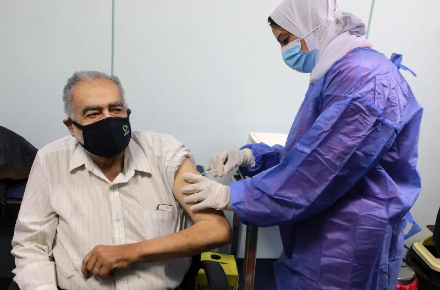 ممرضة تعطي جرعة من لقاح «كورونا» لرجل مسن في أحد مراكز التطعيم بالقاهرة (إ.ب.أ)