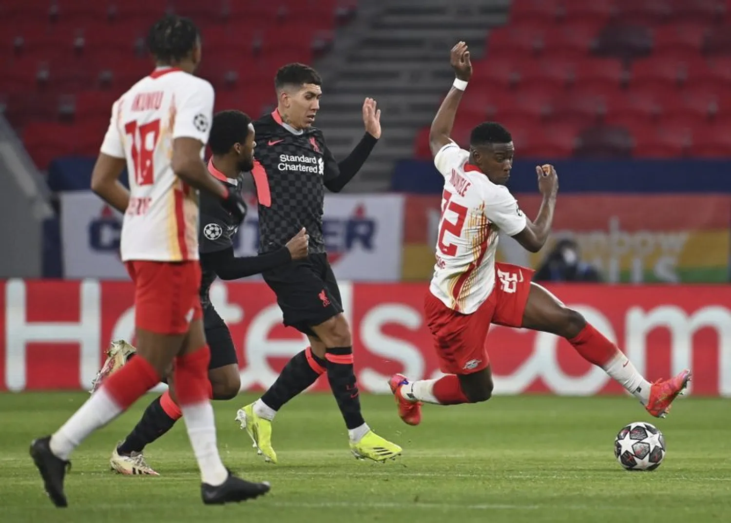 RB Leipzig's Nordi Mukiele, right, tries to get past Liverpool's Roberto Firmino, center, during the Champions League round of 16, first leg, soccer match between RB Leipzig and Liverpool in the Puskas Ferenc Arena in Budapest, Hungary, Tuesday, Feb. 16, 2021. At right Lukas Klostermann of RB Leipzig. (Tibor Illyes/MTI via AP)
