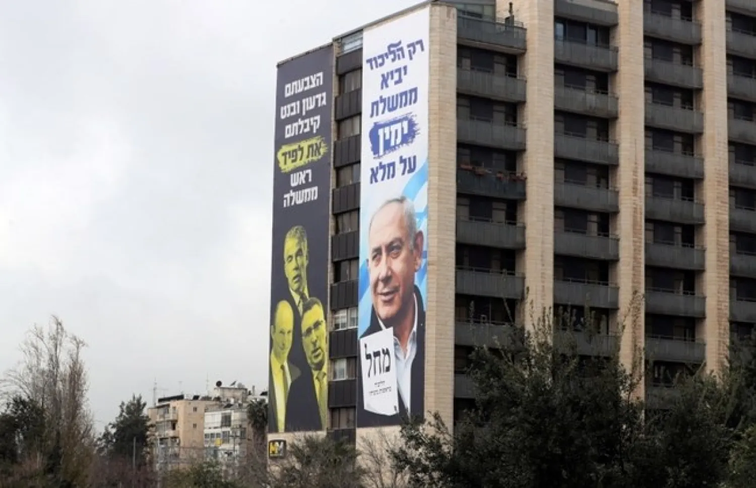 Election campaign posters by Israeli prime minister Benjamin Netanyahu's Likud Party are seen amid coronavirus disease (COVID-19) on a building in Occupied Jerusalem, March 4, 2021. (REUTERS/Ronen Zvulun)


