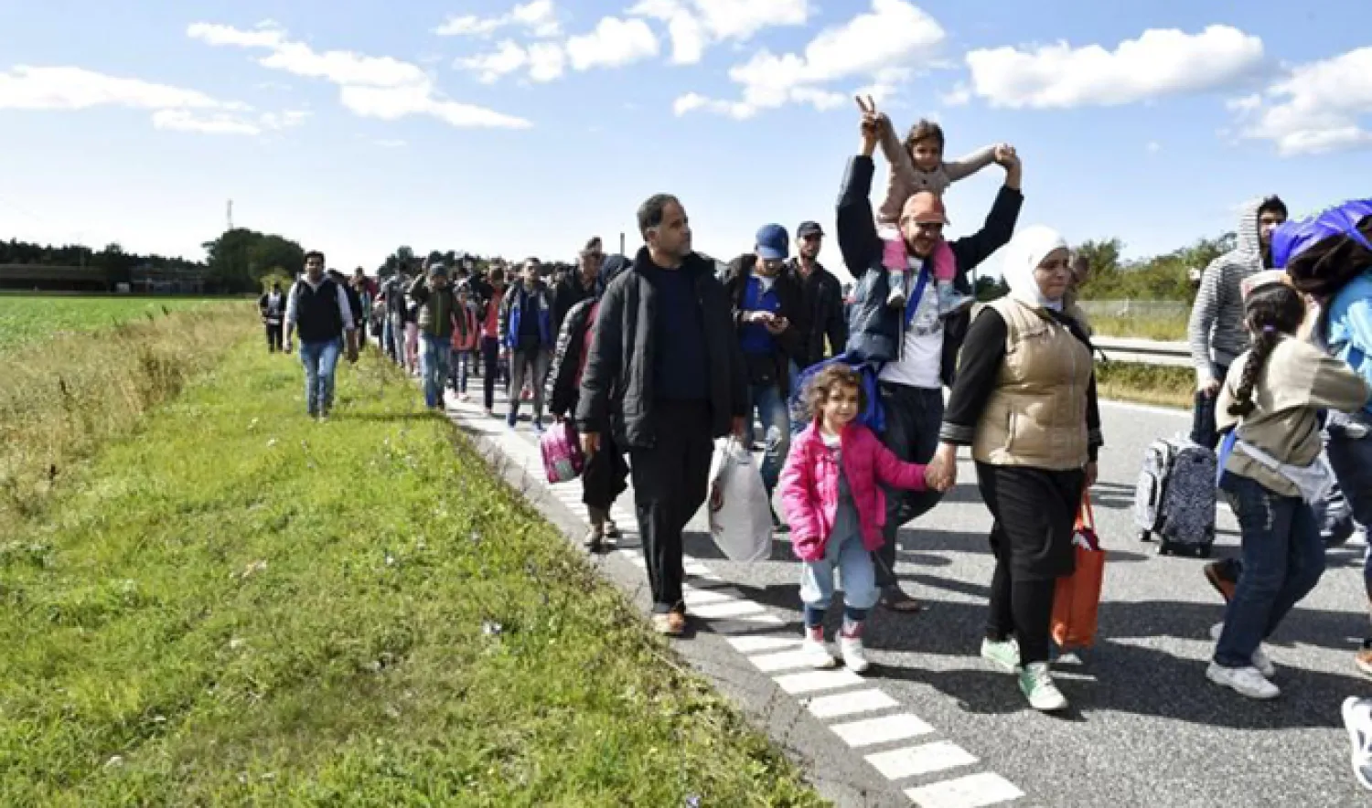 A large group of migrants, mainly from Syria, walk towards the north on a highway in Denmark. (Reuters/File)
