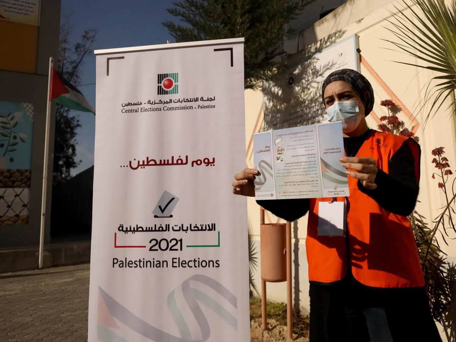 A Palestinian member of the Central Elections Commission displays an information leaflet following the opening of the first Voter Information and Registration Center in Gaza City ahead of polls due later this year. (AFP)