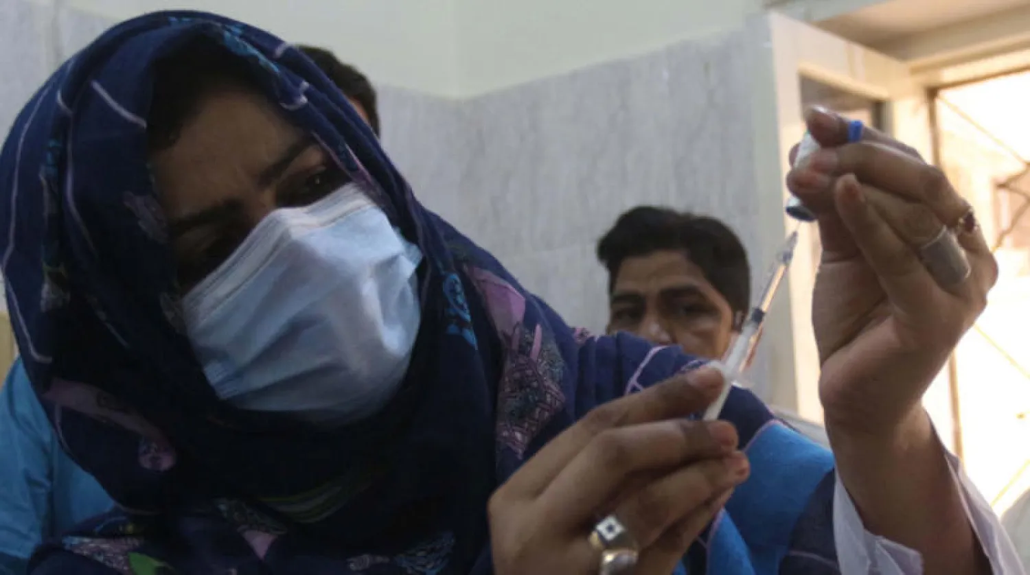 ممرضة تعد جرعة لقاح بمدينة حيدر آباد في باكستان (إ.ب.أ)
