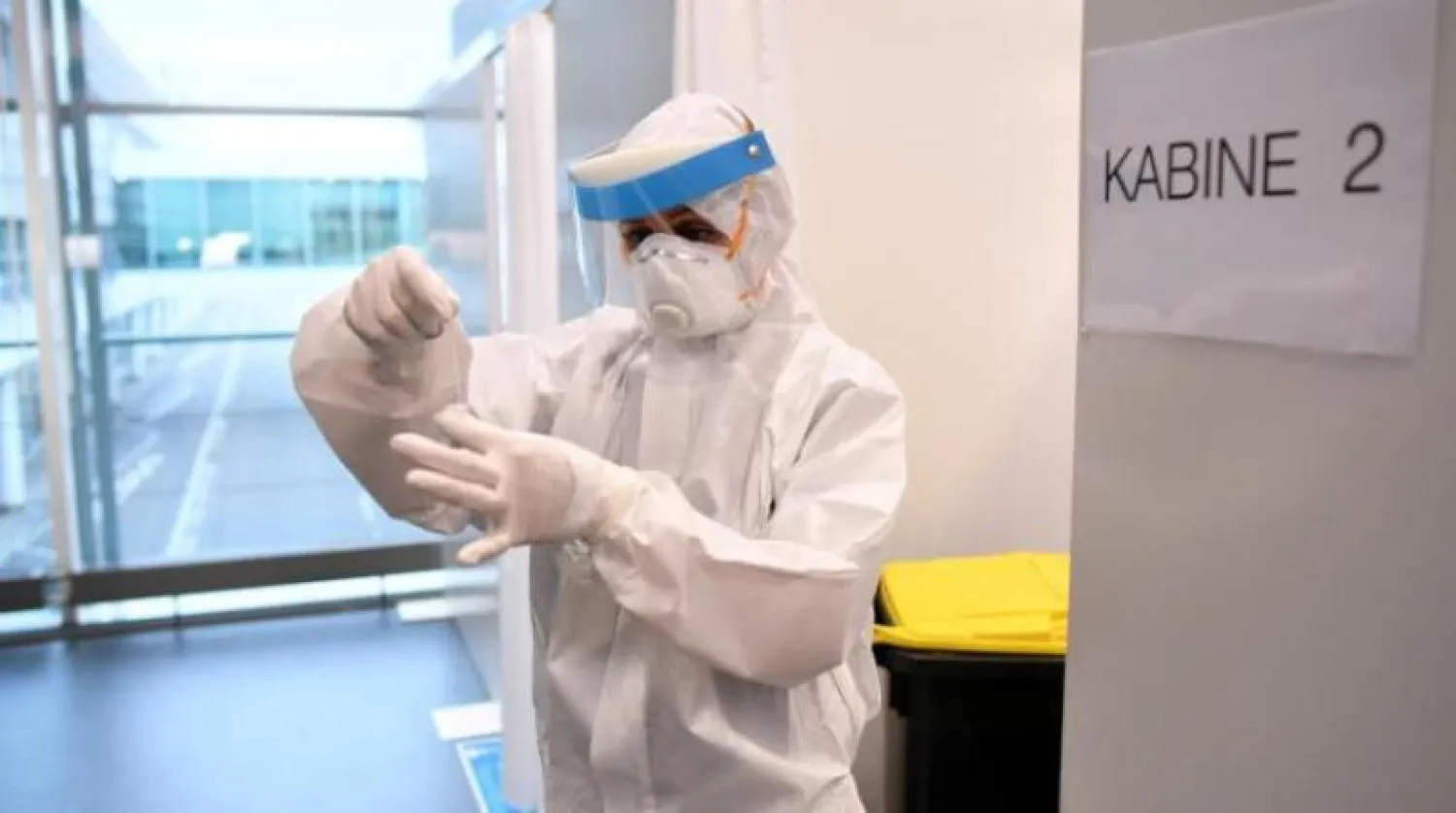 فرد من الطاقم الطبي بأحد مراكز اختبار «كورونا» السريعة في ألمانيا (رويترز)