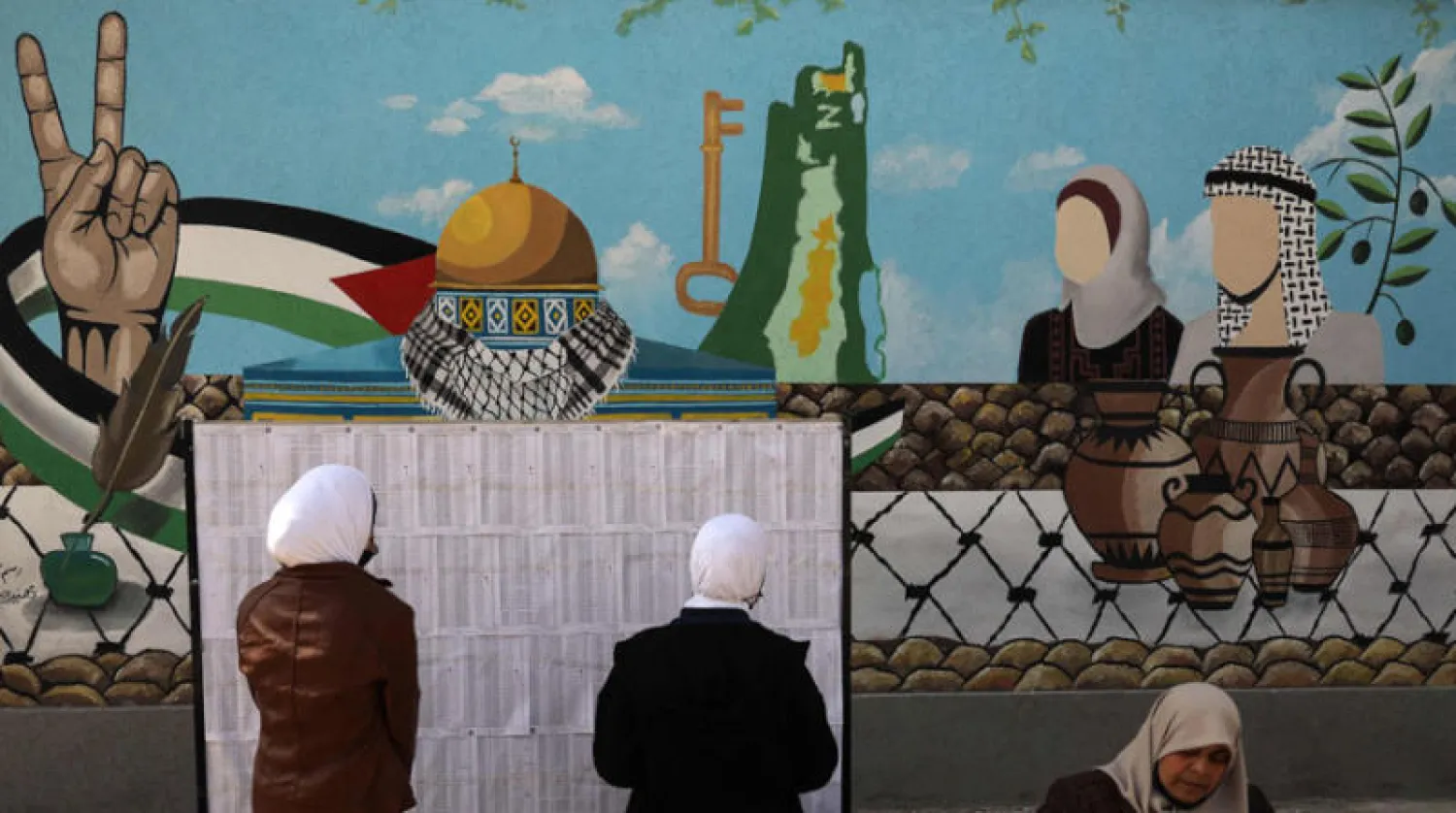 فلسطينيتان تبحثان عن اسميهما في قوائم الناخبين بمركز في غزة (أ.ف.ب)