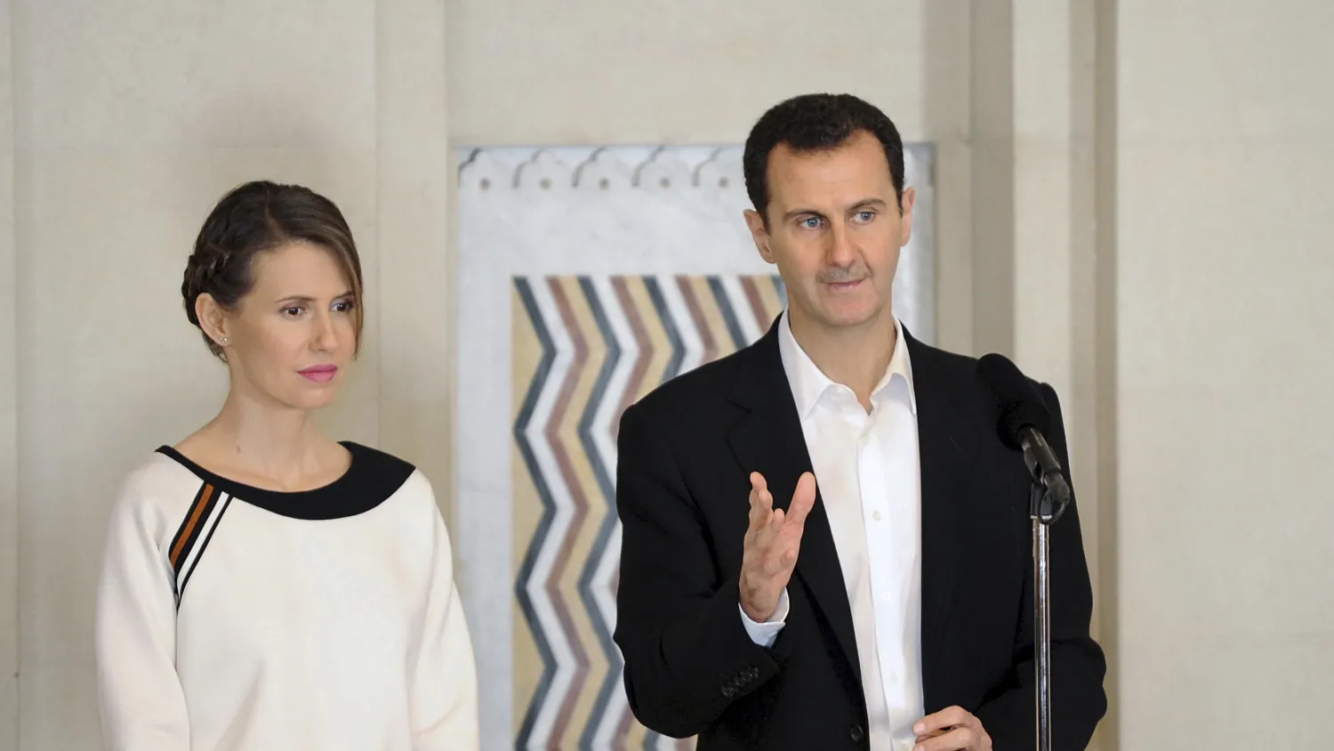 The head of the Syrian regime, Bashar al-Assad, stands next to his wife Asma on March 21, 2016. Reuters