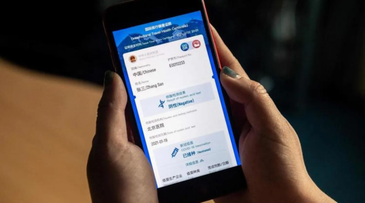 Bir kadın, Çin'in yeni çalışması dijital aşı pasaportuna bakıyor (AFP)
