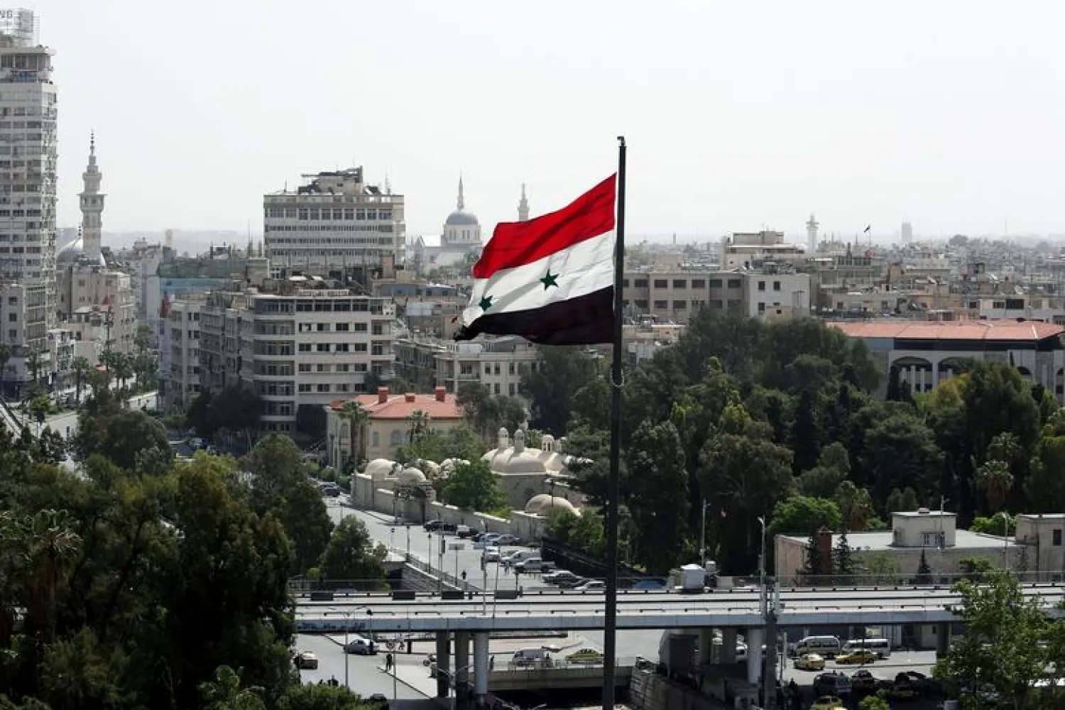 FILE PHOTO: A Syrian flag flutters in Damascus, Syria April 20, 2018. REUTERS/Ali Hashisho 

