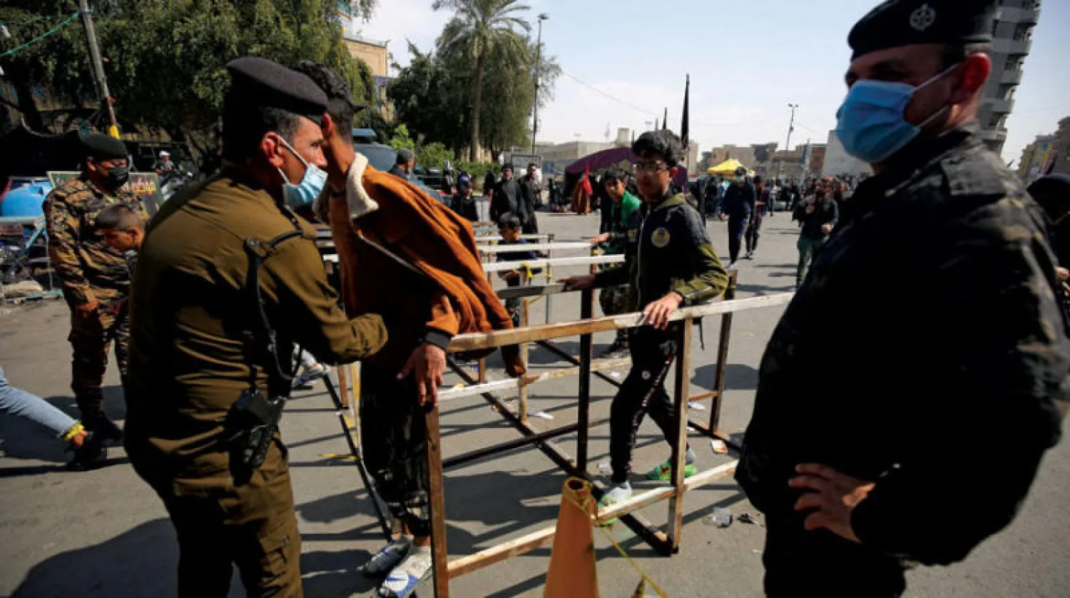 عنصر أمن يفتش أحد زوار مرقد الإمام الكاظم في بغداد أمس (أ.ف.ب)