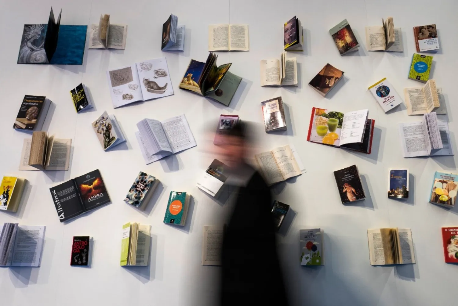 A visitor walks past a book display at the Frankfurt Book Fair on October 13, 2017 in Frankfurt am Main, western Germany. (AFP/John Macdougall)