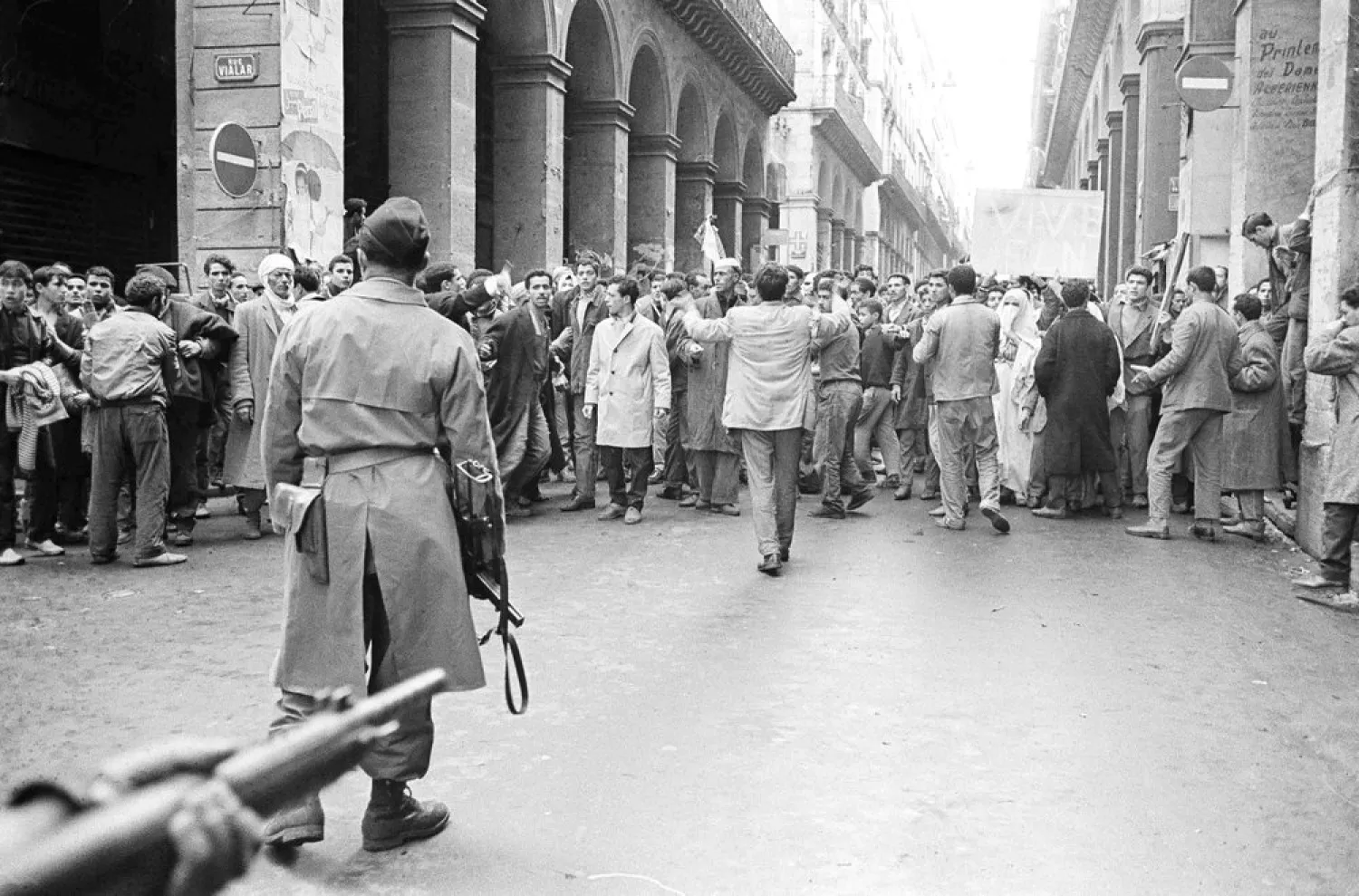In this Dec.14, 1960 file photo, armed French soldiers, foreground, face a shouting mob of Algerians at an entrance to the Casbah native quarter in Algiers. (AP)